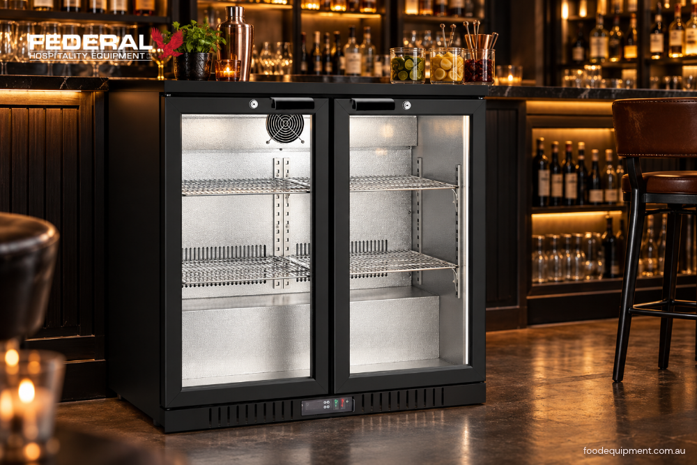 Black two-door glass-front commercial bar fridge with adjustable shelves and digital temperature control in a modern hospitality bar setting.