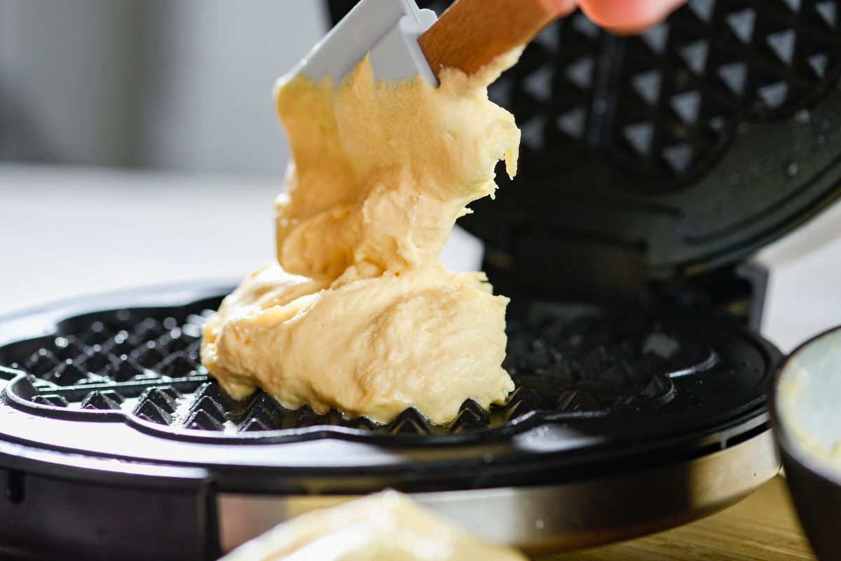 Pouring waffle batter into a waffle maker