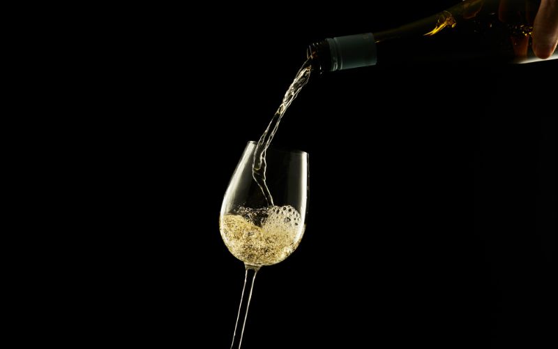 pouring white wine in glass